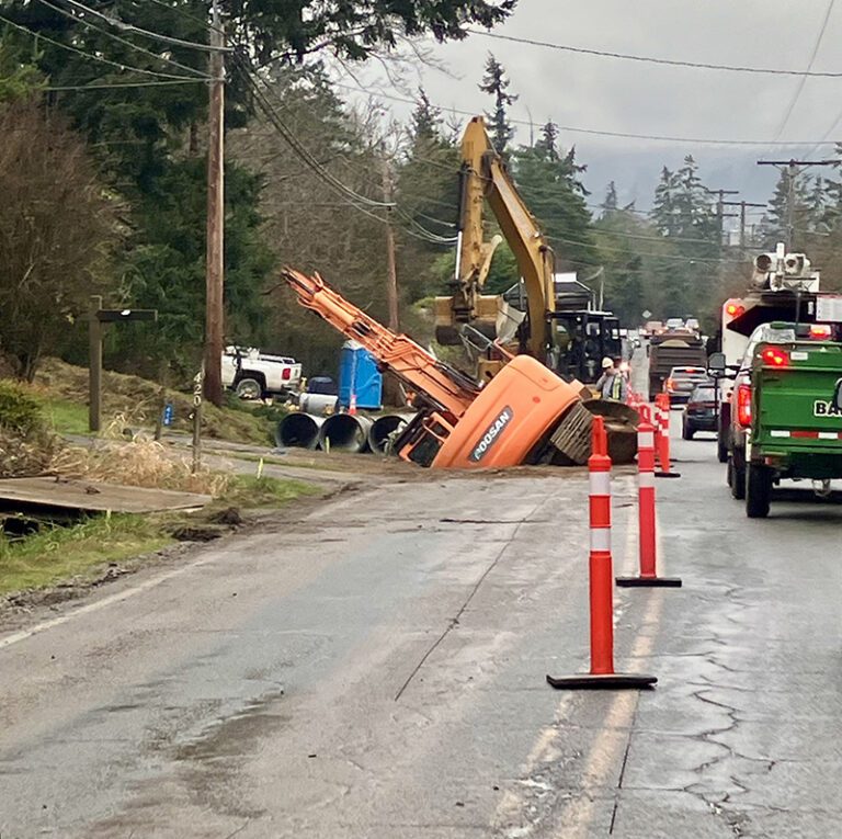 Road gives way under excavator